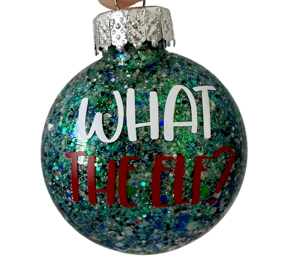 Glitter holiday ornament with What the Elf text and elf prints on back