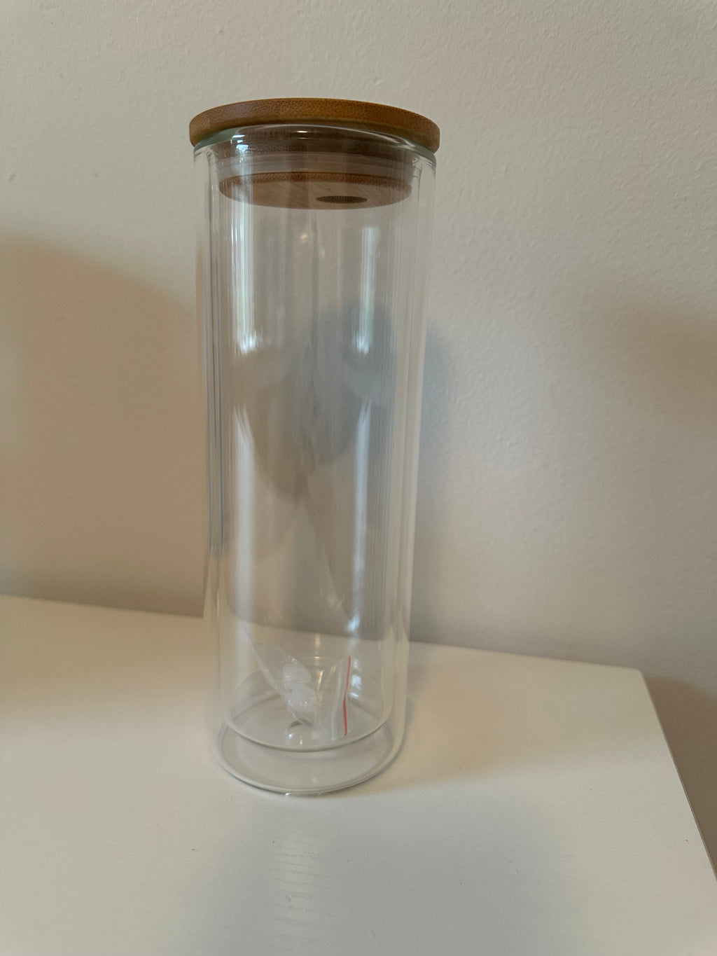 Clear glass bottle with wooden cap on a white background