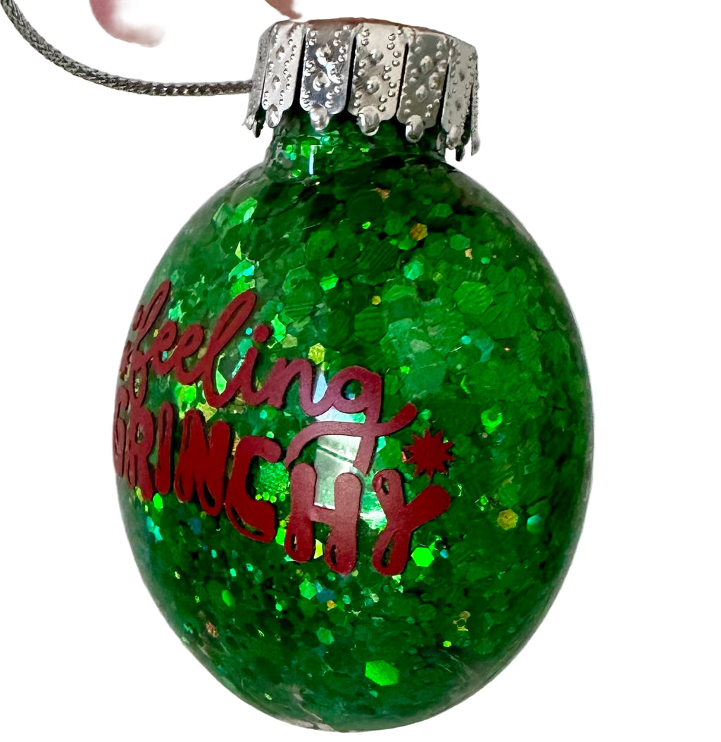 Green glitter flat ornament with Feeling Grinchy phrase