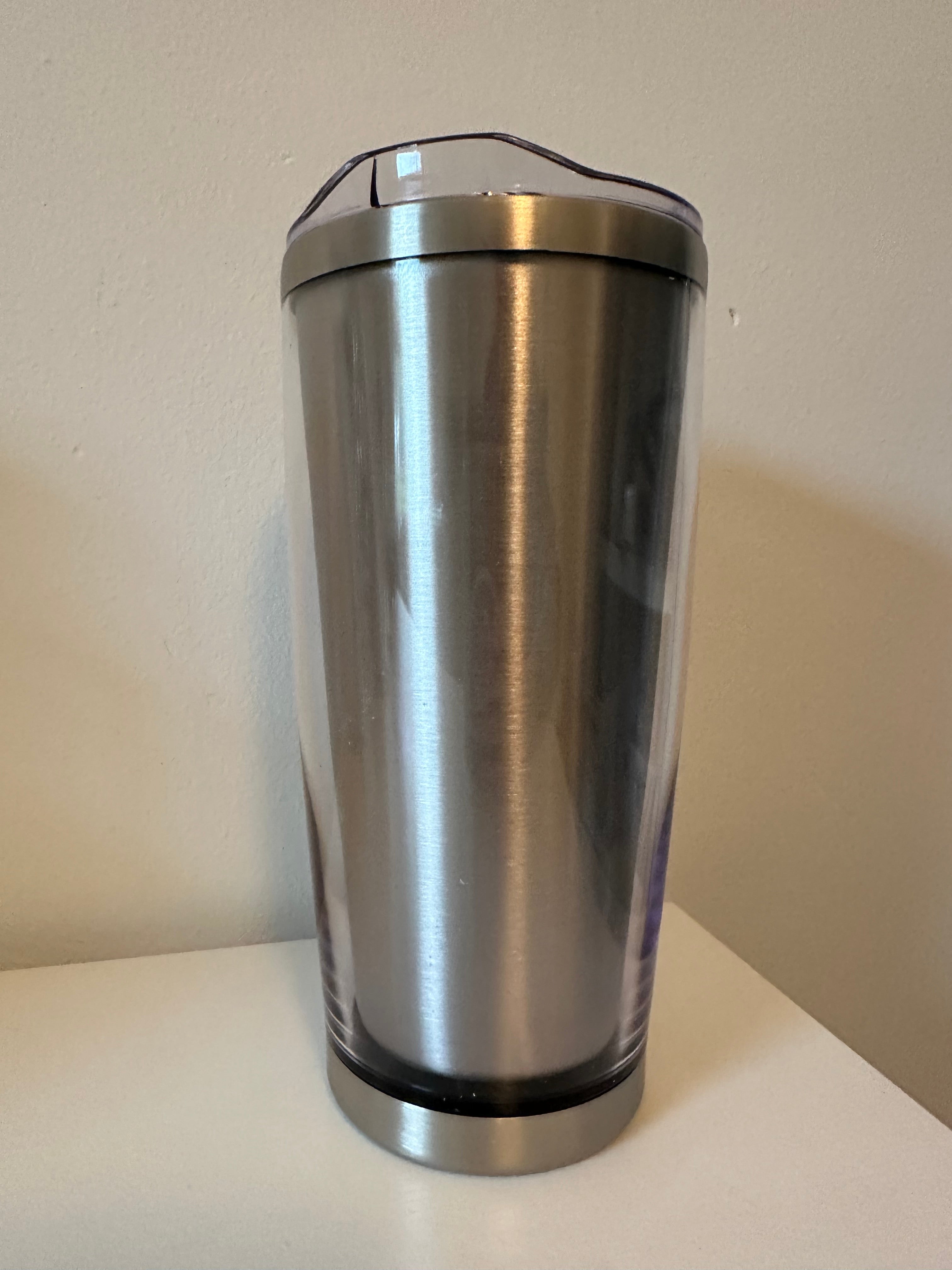 Silver cylindrical object on a beige background