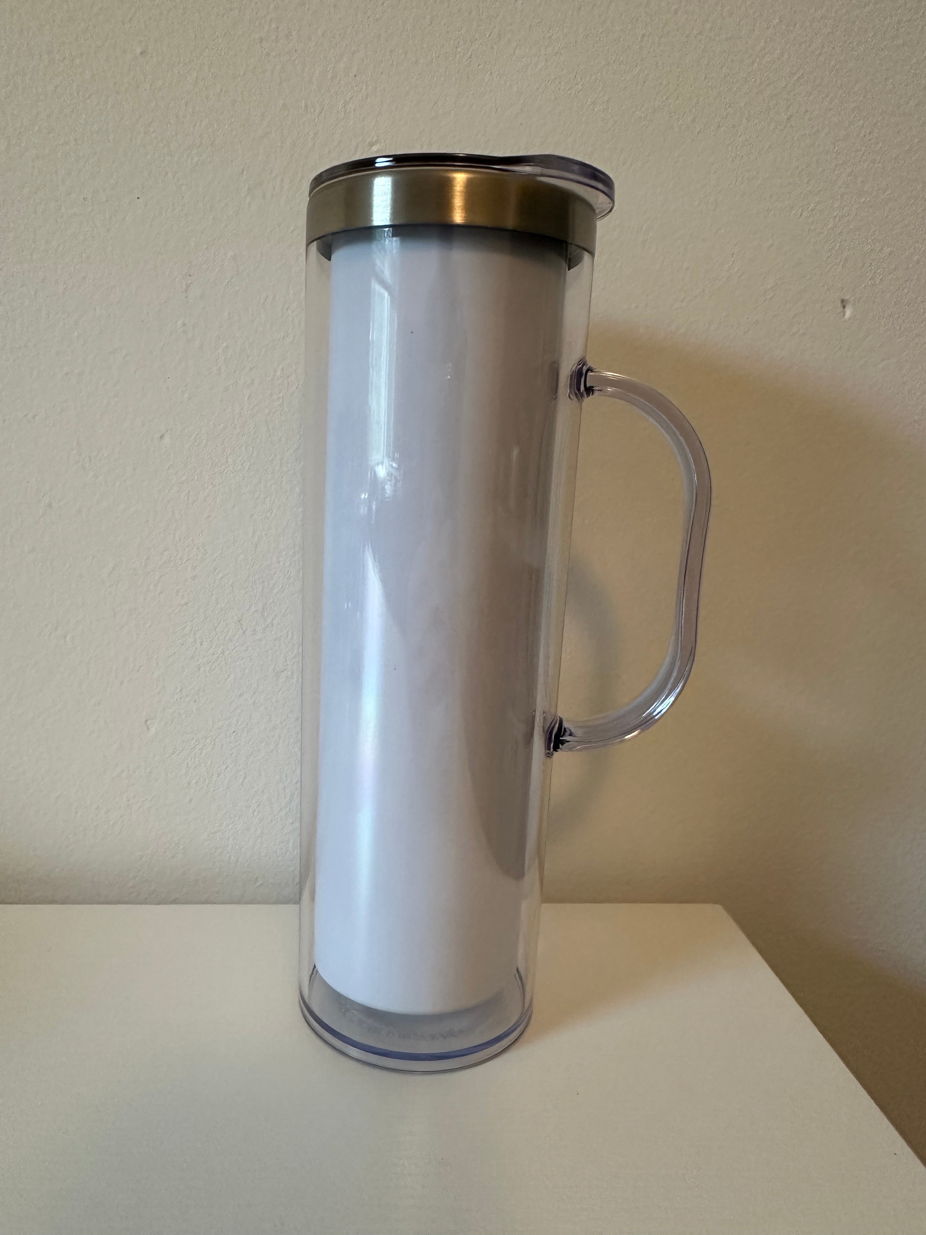 Clear cylindrical container with a handle mounted on a beige wall.