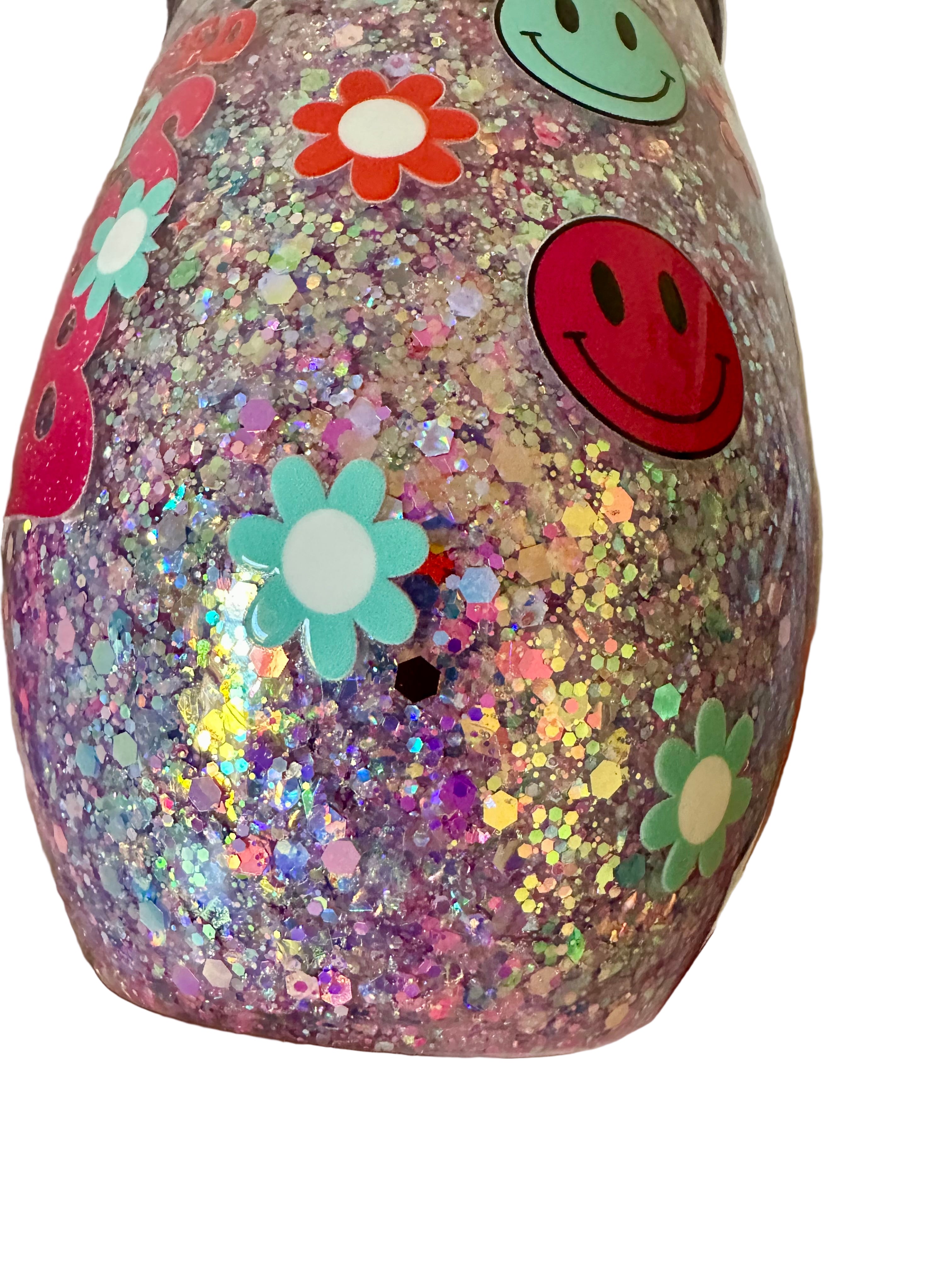 Close-up of glitter wine tumbler with smiley and flower design
