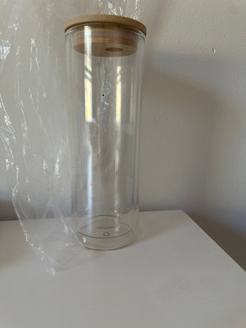 Clear glass jar with wooden lid on a white surface